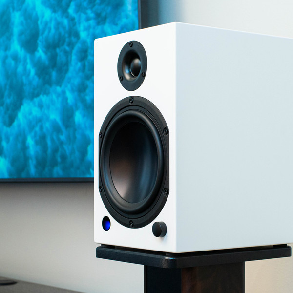 Lifestyle image of the M-Series white speaker next to a television