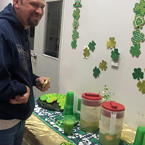 An employee enjoying some refreshments at the office on St. Patrick's Day.