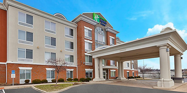 Front face of a four story brick and tan hotel, the Holiday Inn Express & Suites.